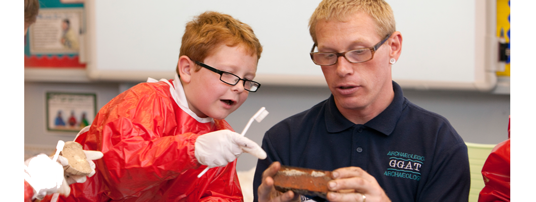 A child asking a GGAT archaeologist about the pot he has justed washed