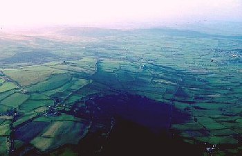 Hill-top, mostly enclosed in late 18th to early 19th century, with ridgeway and series of defensive earthworks of later prehistoric, early medieval, and medieval date.