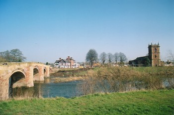 Modern expansion of historically important early medieval ecclesiastical centre and by a subsequent medieval nucleated church settlement, close to strategically important river crossing which has substantially expanded as a settlement in the 20th century.