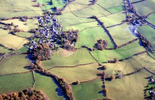 The church settlement of Battle first documented in the early 13th century, viewed from the west with The Pool to the right. The battle which resulted in the conquest of the kingdom of Brycheiniog in 1093 is traditionally held to have taken place in the fields in the middle distance, to the south of the village, perhaps on the basis of the placename, though the settlement is actually named after Battle Abbey in Sussex, which drew income from the parish. The ridge and furrow visible in these fields is possibly of medieval origin. Photo: CPAT 05-C-146.