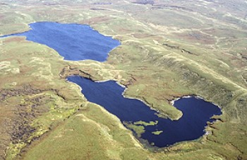 Extensive, unenclosed moorland with small upland lakes, peat bogs, prehistoric funerary and ritual monuments and small and dispersed medieval to early post-medieval encroachments.