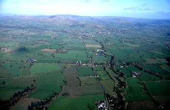 Low-lying land along the Caebitra valley, forming an important route into mid Wales via Sarn and Kerry, with Roman fort and marching camps, medieval grange, medieval and later mills.