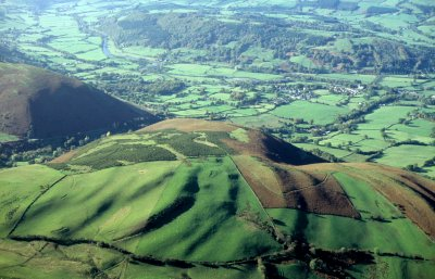 Enclosed moorland on the hills around the southern and eastern rim of the Caersws Basin, substantial parts of which were subject to parliamentary enclosure in the early 19th century.