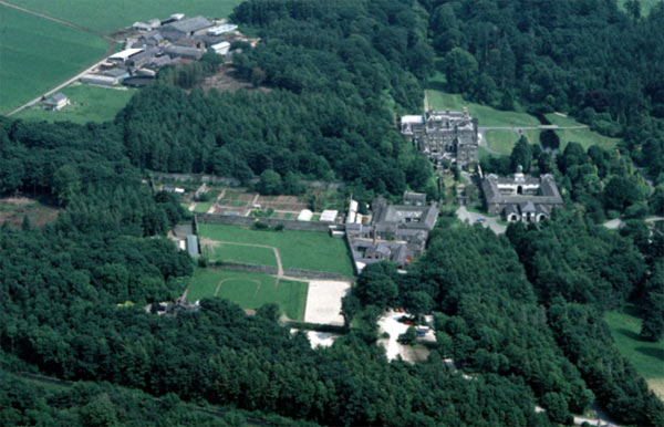A close-up aerial view, looking east, of the core of the Glynllifon estate, showing the main house at the top, the stables just below and the walled kitchen gardens to the left. The Home Farm is to the top left.