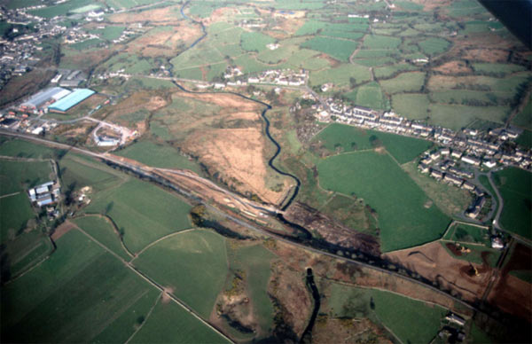 An aerial view, looking south east, which shows the ribbon nature of the main settlement to the right of the photograph, with a twentieth century estate added behind the western side. The medieval core of the settlement is probably towards the left (north) end of the street, close to the river. Penygroes (area 6) is to the left, and the A487 Llanllyfni-Pen y Groes bypass is under construction in the foreground. Most of the rest of the foreground is area 34, while the western end of the Afon Llyfni valley (area 27) is visible centre bottom.