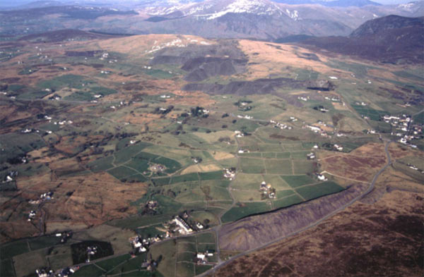 The very distinctive pattern of small, stone-walled fields and dispersed cottage settlement is clearly visible in the centre of this photograph, between the tops of Mynydd y Cilgwyn (foreground) and Moel Tryfan (background) (area 14), both of which bear the traces of slate quarrying and tips.