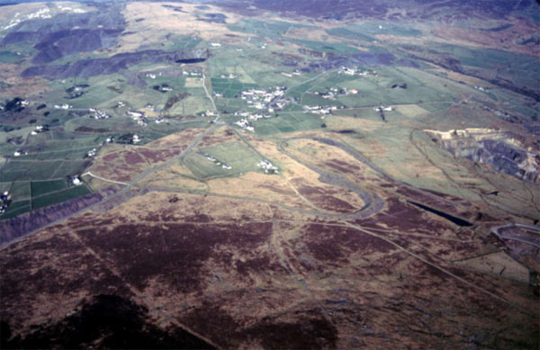 This aerial view, looking north east, shows the unenclosed tops of Mynydd y Cilgwyn, in the foreground, and Moel Tryfan, in the distance, separated by part of area 20, Moel Tryfan enclosures, and Fron (area 21).