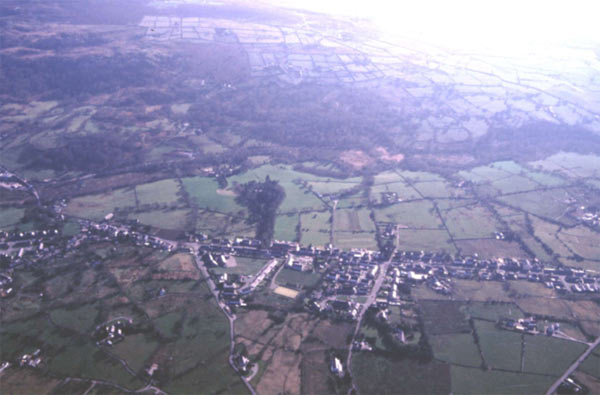 The ribbon nature of the settlement, set along the main road which runs from left (Beddgelert) to right (Caernarfon) across this photograph (looking south west), is clearly visible here. Later settlement has been added to the east of the road which runs along the edge of a drop in to the river valley. The enclosures of area 17 are visible in the foreground.